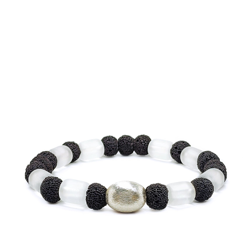 Black lava and clear glass with silver accent laying on a white background