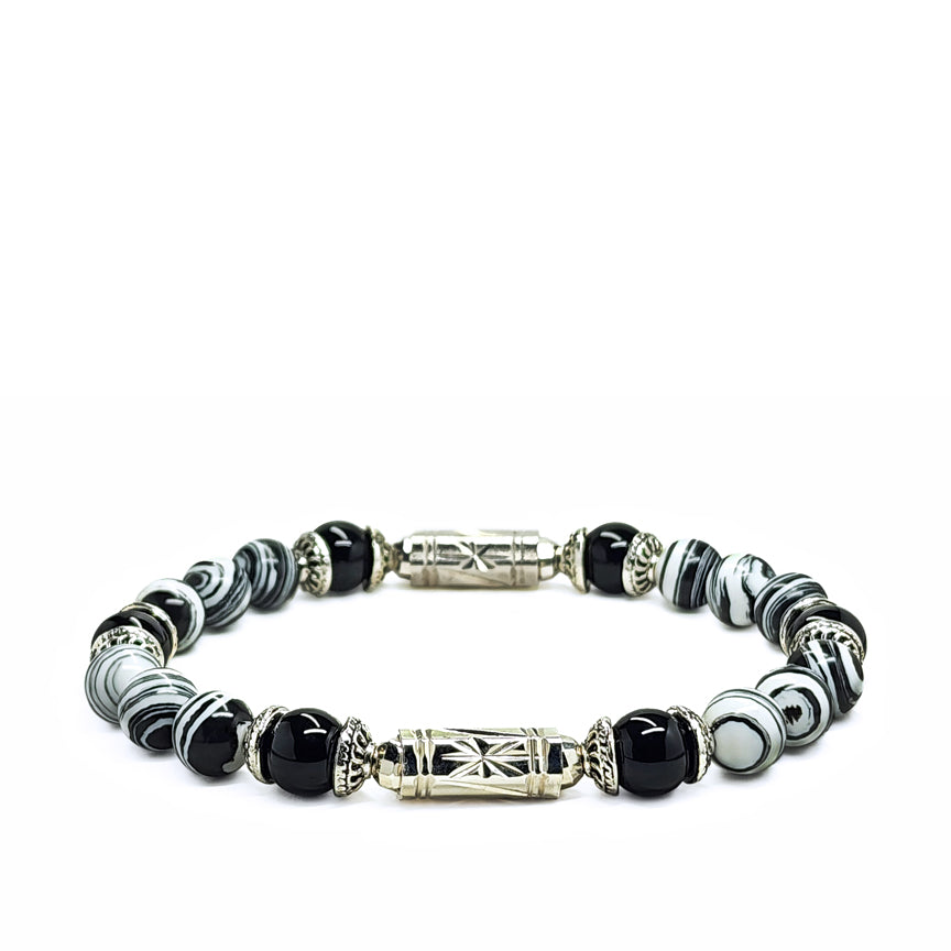 Black and white striped howlite bracelet with silver laying on a white background