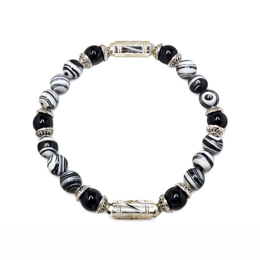 Black and white striped howlite bracelet with silver floating over a white background