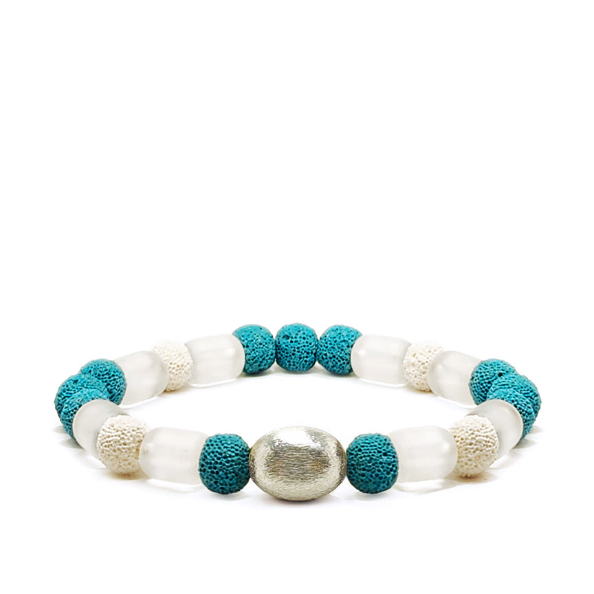 Blue lava and clear glass beads with silver accent laying on a white background