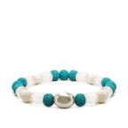 Blue lava and clear glass beads with silver accent laying on a white background