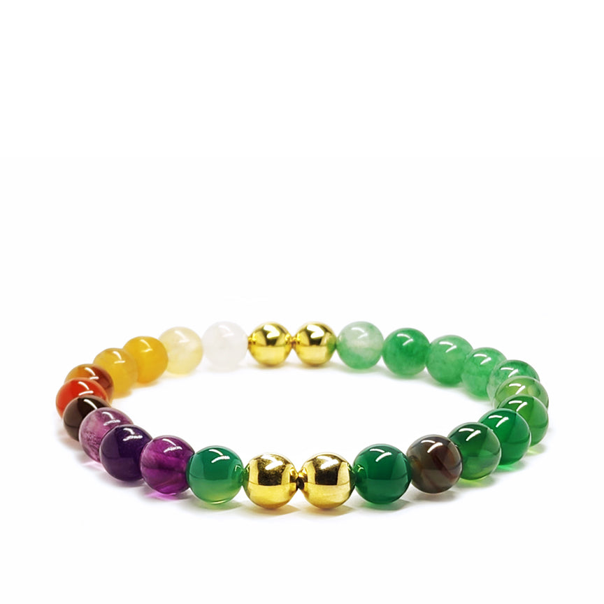 Multicolored onyx beaded bracelet with gold brass accents laying on a white background