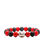 Red coral bracelet with black lava beads and silver accent laying on a white background