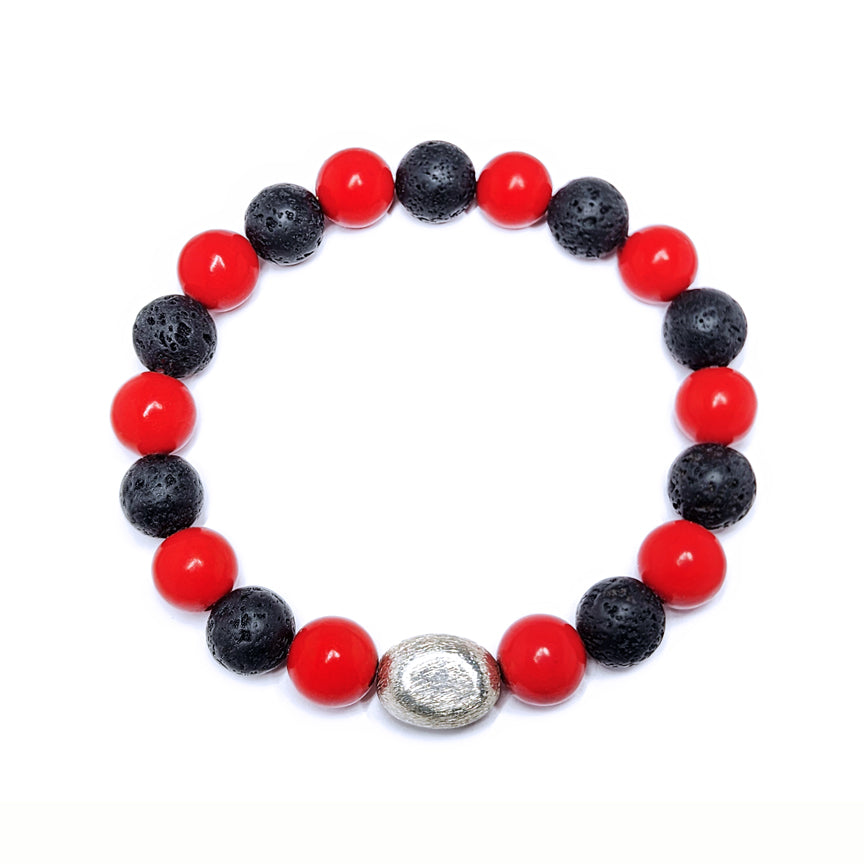 Red coral bracelet with black lava beads and silver accent floating over a white background
