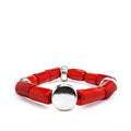Red coral bracelet with silver accents laying on a white background