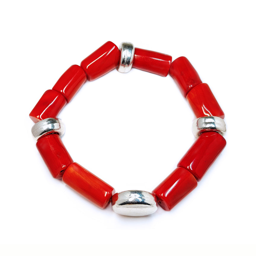 Red coral bracelet with silver accents floating over a white background