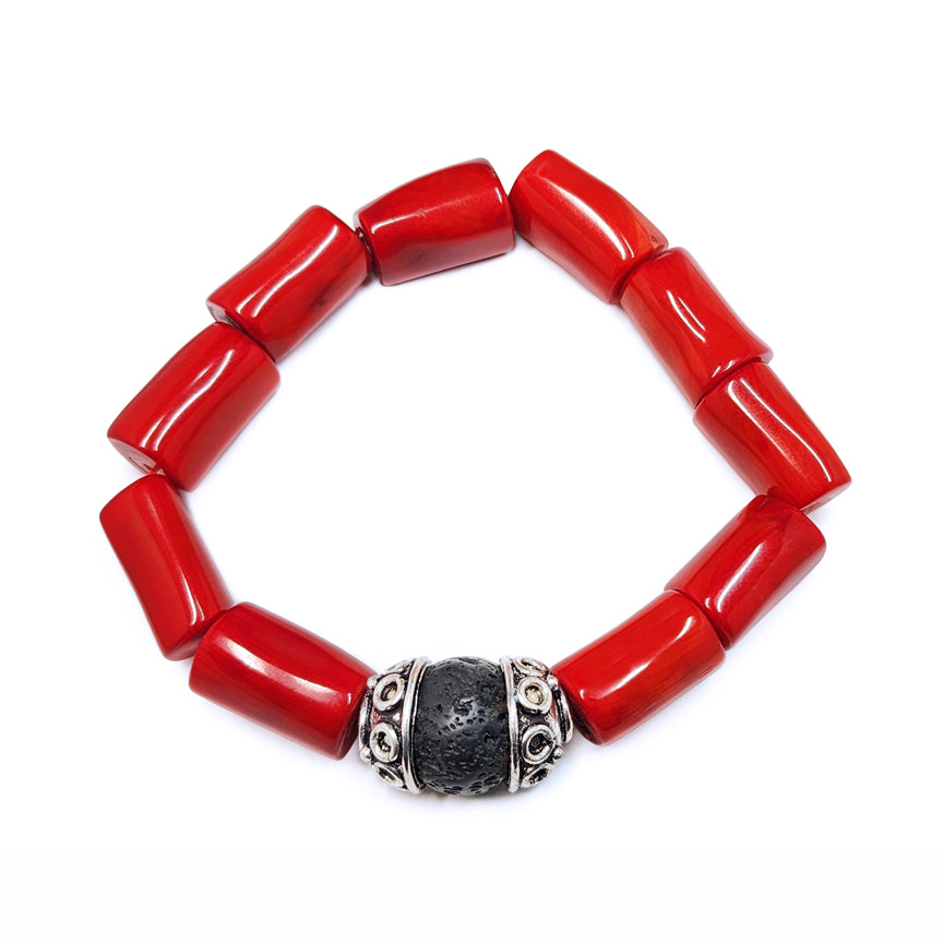 Red coral bracelet with black lava bead and silver floating over a white background