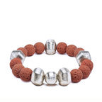 Red lava bracelet with alternating silver beads laying on a white background