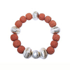 Red lava bracelet with alternating silver beads floating over a white background