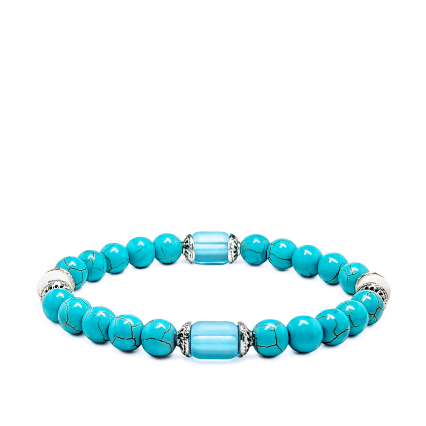 Turquoise howlite with blue glass and silver bracelet laying on a white background