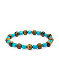 Turquoise and tigers eye bracelet laying on a white background