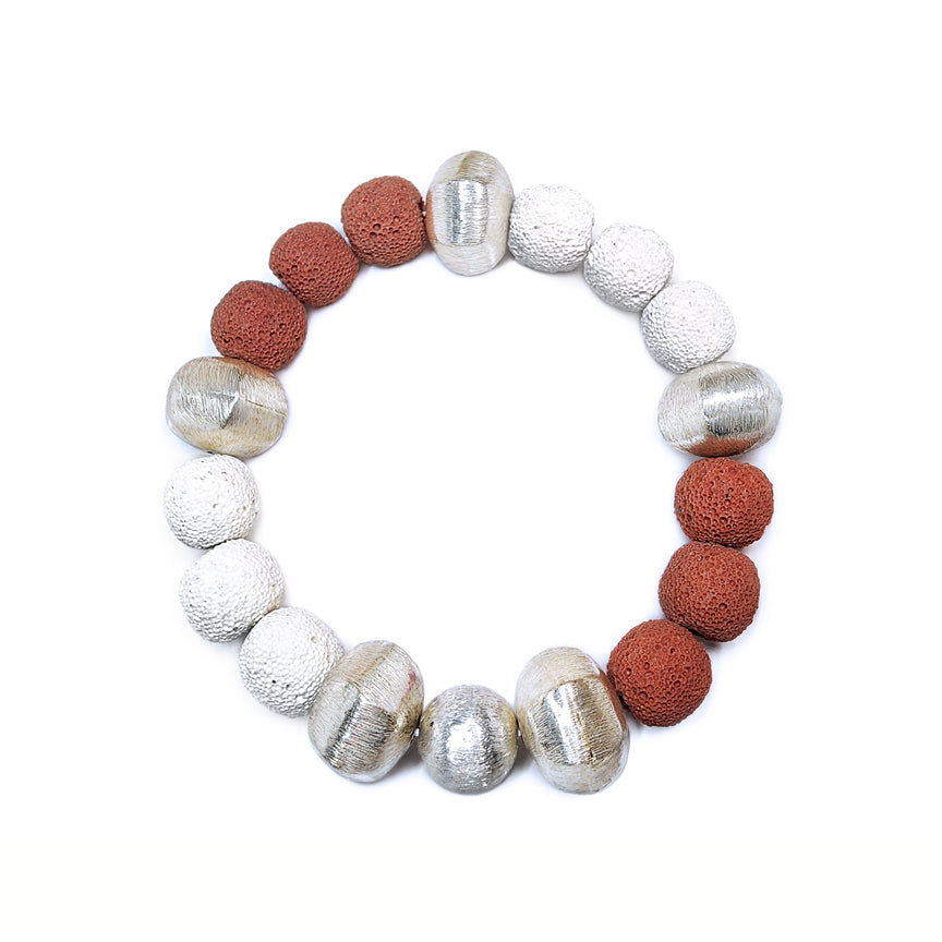 Two-Tone Red and white lava bracelet with alternating silver beads floating over a white background
