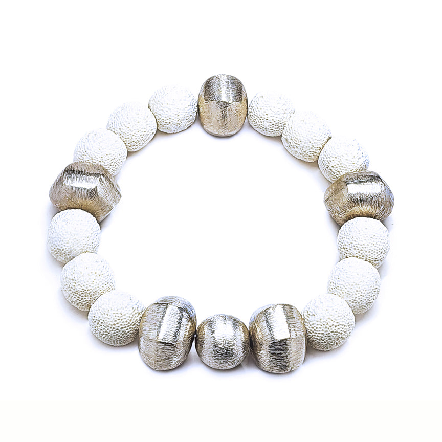 White lava bracelet with alternating silver beads floating over a white background